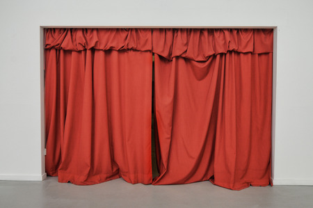 Red curtain closed on a large white doorwayの写真素材