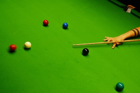 Snooker table with balls and cue handhelded after shot