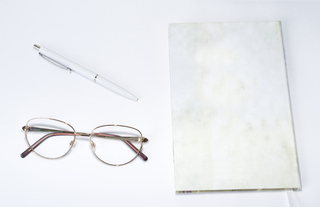 Glasses, pen and notebook on a table