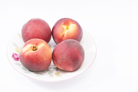 four whole ripe peach on a plateの写真素材
