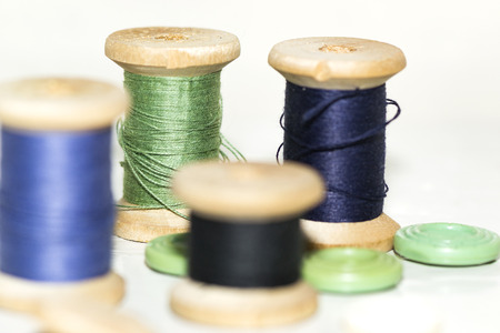 wooden coils with blue and green threads and buttonsの写真素材