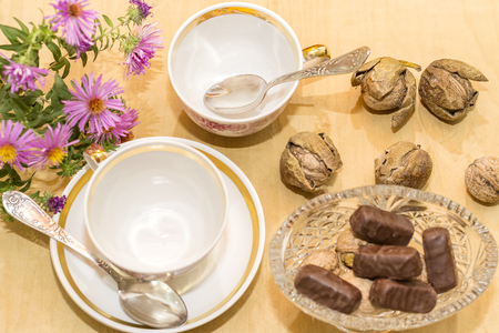 chocolate in a vase, two cups and spoons, flowers top viewの写真素材