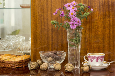 crystal vases with flowers, candy and nuts on a polished surfaceの写真素材