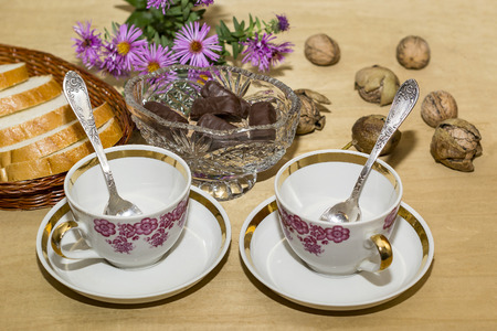 empty tea cups and chocolate on a wooden tableの写真素材