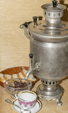 samovar on an old wooden table and tea cup with spoonの写真素材