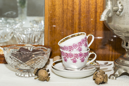 tea cups, crystal vase with nuts and chocolateの写真素材