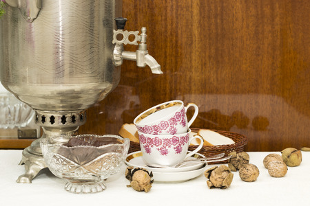 two cups, spoons, walnuts and bread on a polished surfaceの写真素材