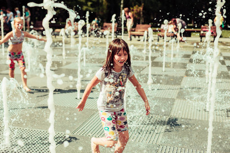 children in the park bathed in the fountainの写真素材