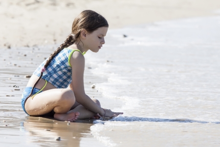 Girl playing in sand  on the beachの写真素材