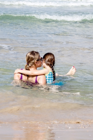 Rear view of a mother and daughter at the beachの写真素材