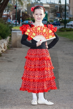 Happy little pretty girl in spanish red dressの写真素材