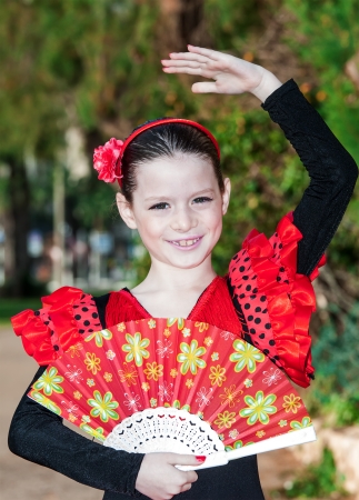 Happy little pretty girl in spanish red dressの写真素材