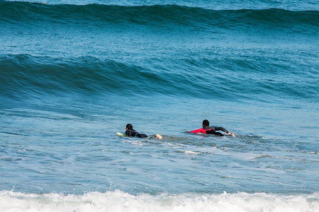 Surfers on the way to the sea waiting for wavesの写真素材
