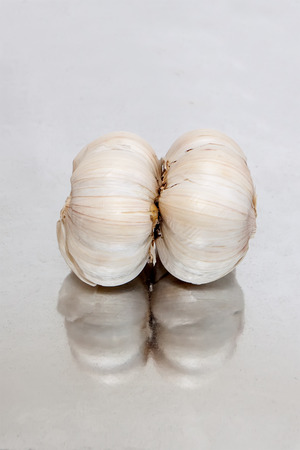 Garlic lying on the mirror surfaceの写真素材