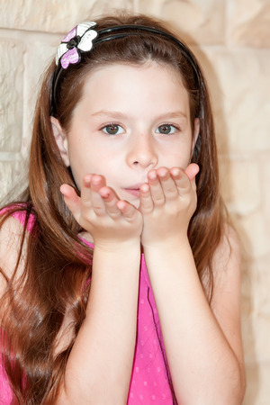girl in a pink dress stand at a  stone wallの写真素材