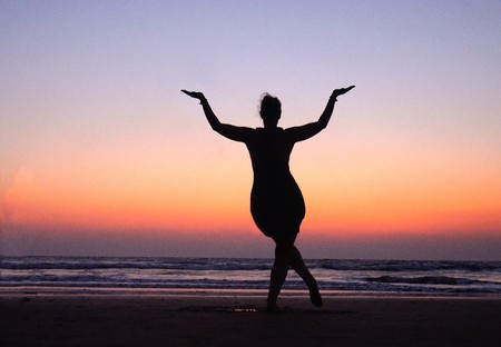 Woman in Pose dancing Shiva in Sunset pink Sky near sea  in India. Dance is  useful !   Symbol of Indiaの写真素材