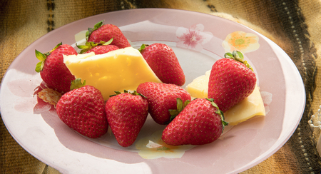 Cheese  and  strawberries  on  rose plateの写真素材