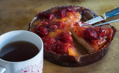 Tasty cake  with fruits - on top -
strawberries and tangerines in jelly  , and  cup of teaの写真素材
