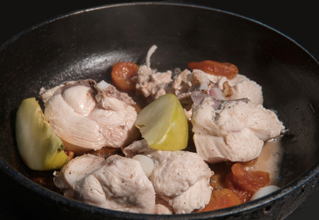 cooking chicken breast- stewing with dried apricots and apples   on the panの写真素材
