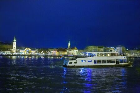 A pleasure boat on Danuba river  and a part of Budapest called Buda at nightの写真素材