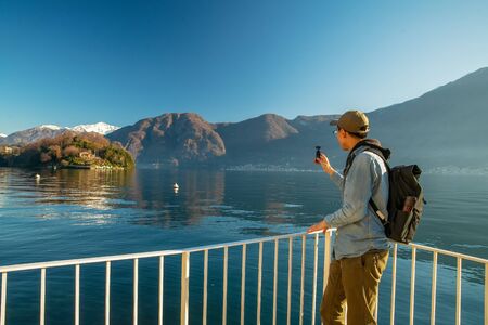 Chinese tourist makes a video of beautiful landscapes on Lake Como. beautiful sunny  day  in Nortern Italy.の写真素材