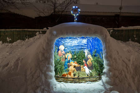 Scene of the birth of the infant Christ in a stable next to the church in Yaroslavl, Moscow St. Petersburg, Moscow region in night time - cold russian winter (snow)の写真素材