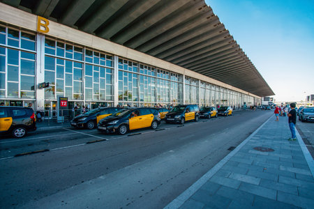 08-28-2022 Barcelona, Spain. Airport of Barcelona - El Prat de Llobregat, Barcelona, - taxi cars and people in distance - sunny summer day! Some spanish tourists fly to Norway from hot Spainのeditorial素材