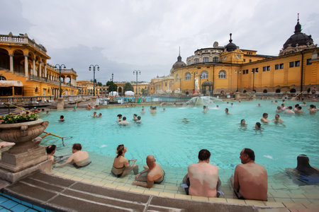 04-26-2014 Budapest Hungary. Old Szechenyi baths (1909) in Budapest: people enjoy a treatment and relaxation with warm mineral water (healthy lifestyle) outdoors in Aprilのeditorial素材