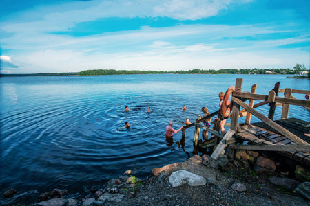 06-22-2022 Helsinki, Finland. People swimming in lake after sauna - fantastic summer (weekday in Helsinki) Healthy lifestyle!のeditorial素材