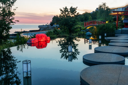 Fantastic Japanese garden in Crimea Ukraine (now occupied by Russia). in sunset lights and Black Sea at left hand.. Japanese bridge in distance.の写真素材