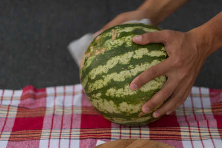 Fresh watermelon is laid on a red rugの写真素材