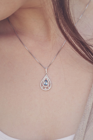 Detal of woman wearing a luxury pendantの写真素材
