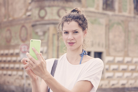 Young woman with her smart phone taking pictures.の写真素材