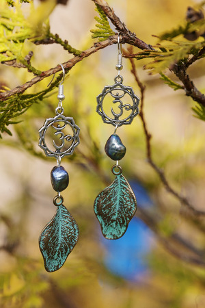 Earrings with burdock leaves and river black pearlsの写真素材