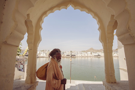 Sadhu Baba with Pushkar holy lake on the background, Pushkar city, Rajasthan, India, February 15, 2018のeditorial素材