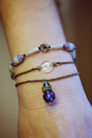 Three bracelets with natural stone beads on female hand