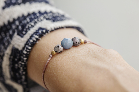Female wrist wearing tiny jewelry bracelet with mineral stone beadsの写真素材