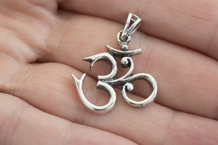 Silver pendant on female hand macro detailの写真素材