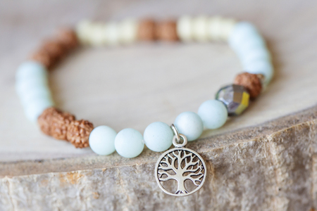 Mineral stone amazonite and tree pendant bead bracelet on natural wooden backgroundの写真素材