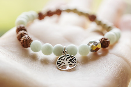Mineral stone amazonite and tree pendant bead bracelet on natural wooden backgroundの写真素材
