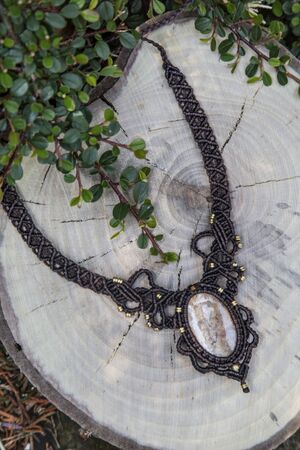 Macrame necklace with natural mineral gemstone on natural backgroundの写真素材