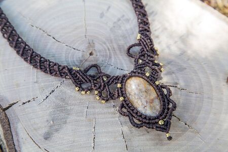Macrame necklace with natural mineral gemstone on natural backgroundの写真素材