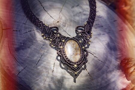 Macrame necklace with natural mineral gemstone on natural backgroundの写真素材