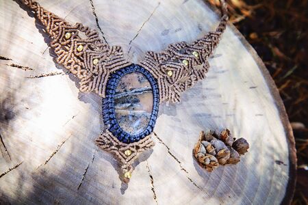 Macrame necklace with natural mineral gemstone on natural backgroundの写真素材