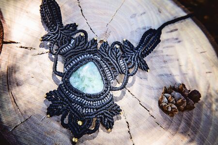 Macrame necklace with natural mineral gemstone on natural backgroundの写真素材