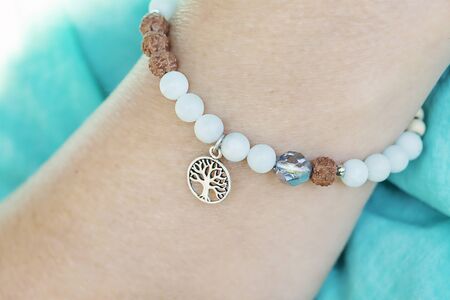 Mineral amazonite and rudraksha beads bracelet with tree pendant on female wristの写真素材