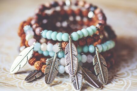 metal feather pendant mineral stone yoga bracelets on decorative natural boho backgroundの写真素材