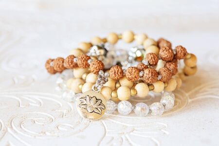 Jewelry mala necklace with natural mineral beads on white wooden decorative background