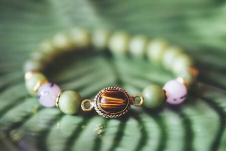 Tyger eye mineral stone jade mineral beads fashionable bracelet on green backgroundの写真素材