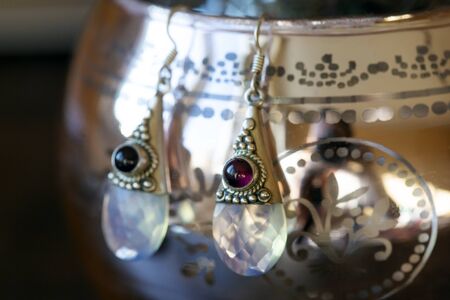 fazeted opalite stone garnet silver earrings on decorative backgroundの写真素材